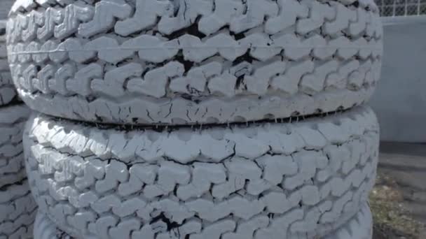 Neumáticos apilados y pintados de blanco — Vídeos de Stock
