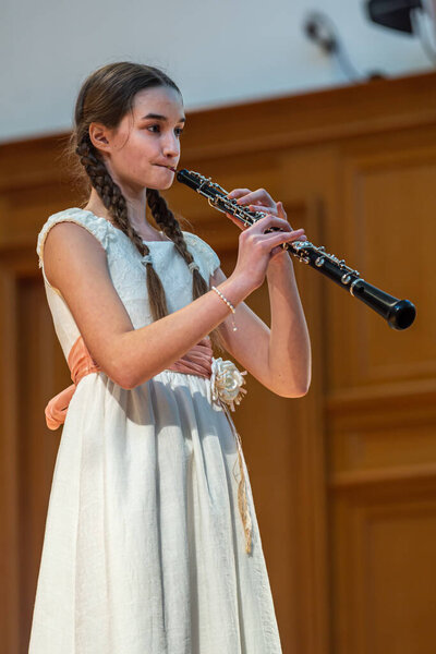 2020.02.15, Moscow, Russia. reporting concert of the orchestra and soloists of secondary and senior students of the music school named after Alekseev. oboe player girl performs a musical play.