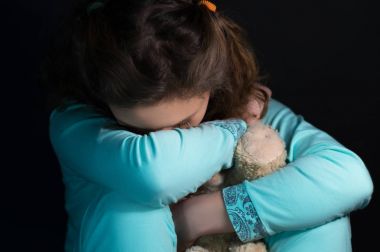 Genç depresyon, oyuncak ayı tutan kız ağlıyor