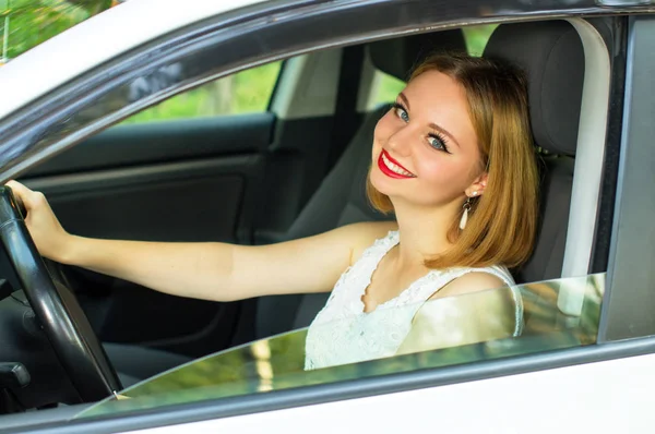 Menina bonita sentada em um carro de luxo — Fotografia de Stock