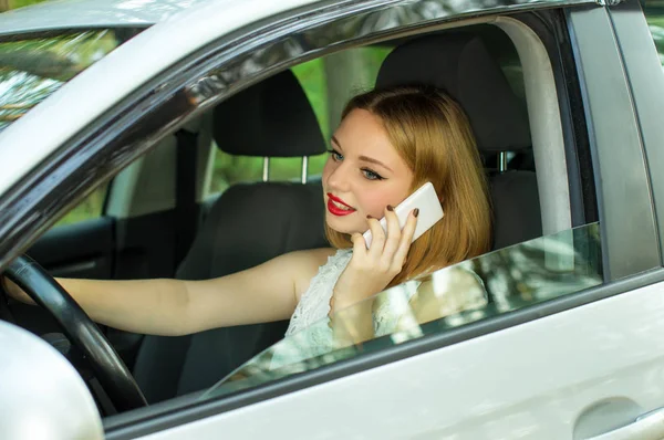 Hermosa chica hablando mientras conduce en el coche por teléfono — Foto de Stock