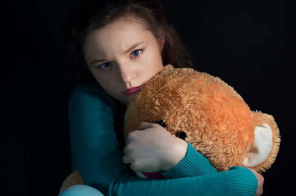 Menina adolescente bonita com ursinho de pelúcia no escuro — Fotografia de Stock