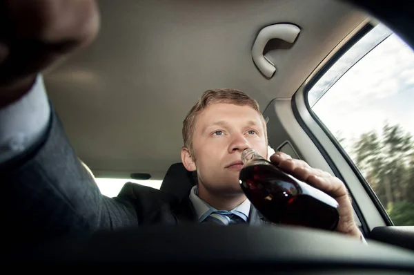 Driver drinks alcohol while driving — Stock Photo, Image