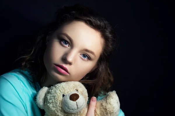 Chica con oso de peluche en la oscuridad — Foto de Stock