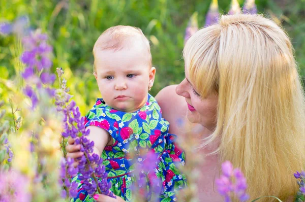 Щаслива мати з дочкою, розглянемо квіти на відкритому повітрі — стокове фото
