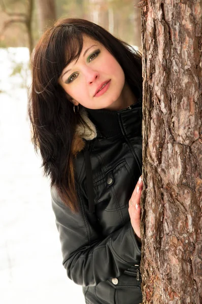 Piękna brunetka dziewczyna stoi w pobliżu drzewa — Zdjęcie stockowe