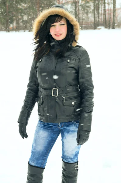 Vacker flicka vilar på naturen, snön faller — Stockfoto
