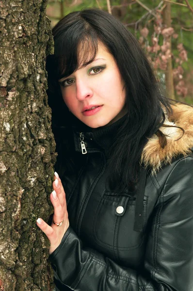 Menina de casaco preto caminha na natureza — Fotografia de Stock