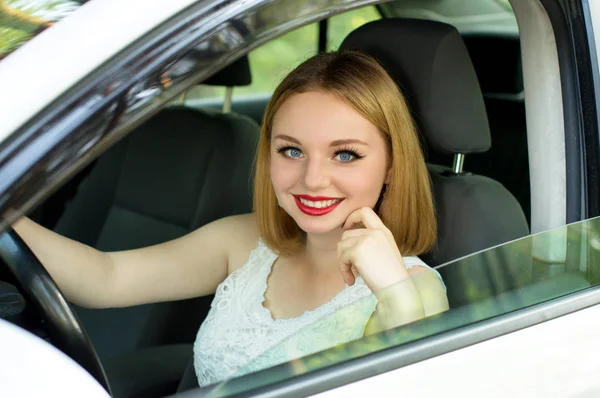 Schönes Mädchen sitzt im Auto Stockbild