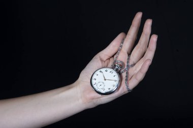 Siyah arka planda gümüş bir cep saati.