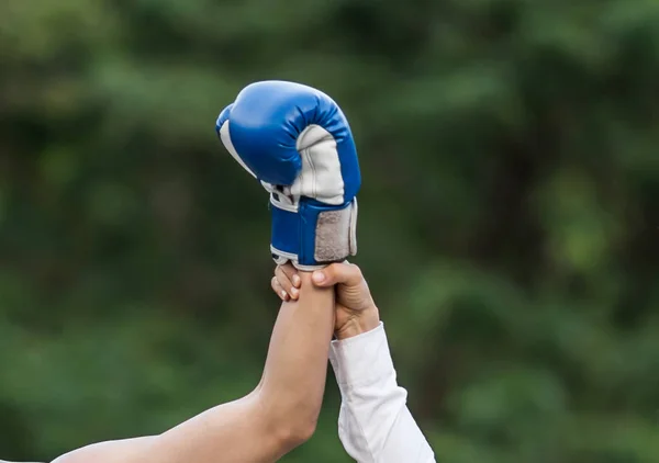 Raising a hand is the winner of a male boxer on a boxing ring. — Stock Photo, Image