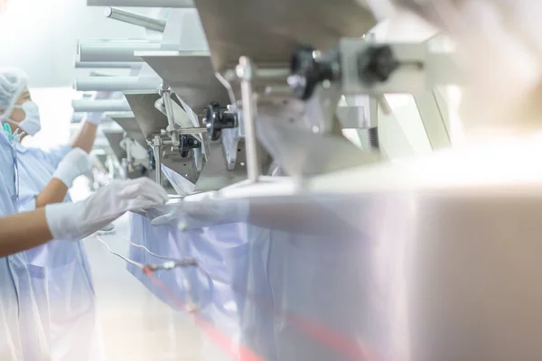 İlaç şişelerini eczacının konveyör bandına transfer et.