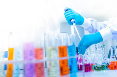 Mavi lastik eldiven giyen bilim adamlarının elleri