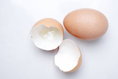 Eggshell and hen's egg on a light white marble background in the