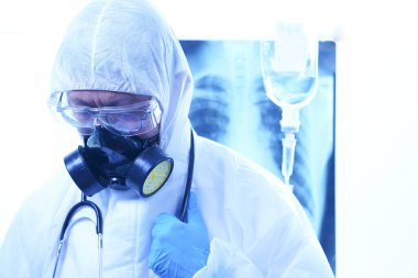 Coronavirus ya da Covid-19 konsepti, koruyucu kıyafetli erkek doktor hastanedeki hastalara ilaç veriyor. Akciğer röntgeni film imha geçmişi. Sığ odak etkisi.