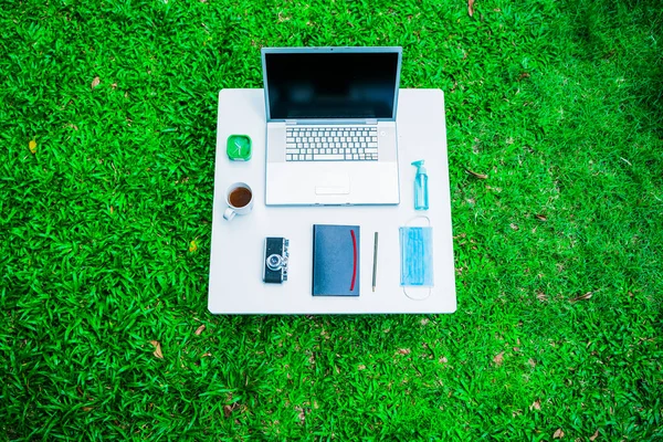 Coronavirüs veya covid-19 salgın salgını sonrası meydana gelen yeni normal değişim sırasında iş ofisindeki sosyal mesafeleme politikası çerçevesinde çalışmak üzere masanızın üzerinde tıbbi maske ve jel alkol bulunmaktadır.