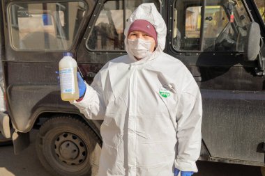 RAMENSKOYE, RUSSIA - 26 Mart 2020: Kadın bir dezenfeksiyon çözeltisi tutar. COVID-19 enfeksiyonu ve kitle alımının yayılmasını önlemek için önlemler