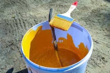 Bir kova sarı boya ve bir fırça.