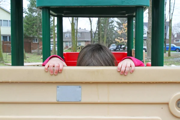 Kind handen vasthouden aan kunststof speeltoestellen park — Stockfoto