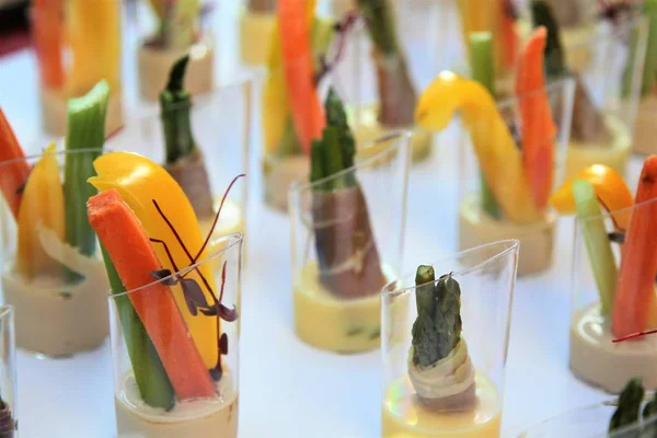 Mesa buffet con hors d 'oeuvres de verduras cortadas sobre un mantel blanco —  Fotos de Stock