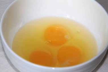 Üç kırık yumurta beyaz bir kase