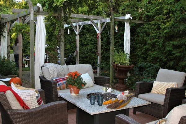 Outdoor seating arrangement around a gas fire pit table in the fall