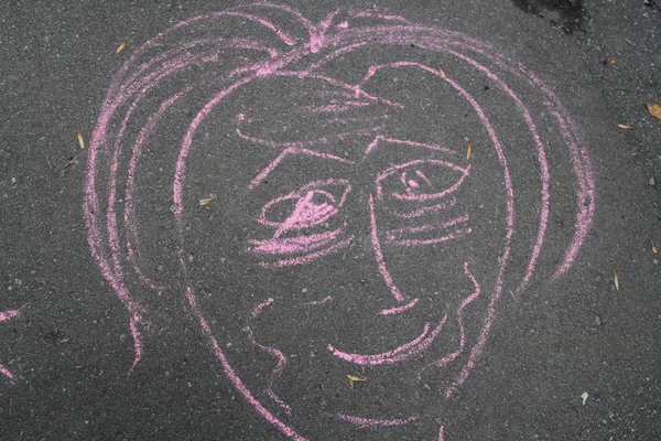 Drawing of a face shape in pink chalk