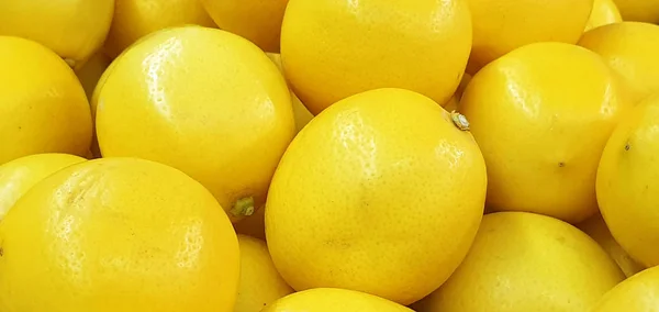 Hintergrund reifer gelber Zitronen, schmackhafter, ungewöhnlicher Fruchthintergrund — Stockfoto