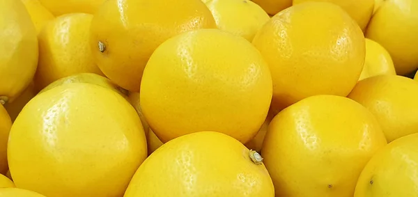Hintergrund reifer gelber Zitronen, schmackhafter, ungewöhnlicher Fruchthintergrund — Stockfoto