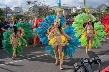Katılımcılar carnival eşarplı parlak kostümleri.
