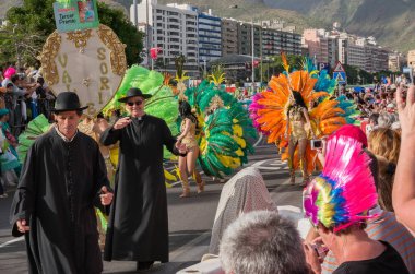 Katılımcılar carnival cassocks ön planda.