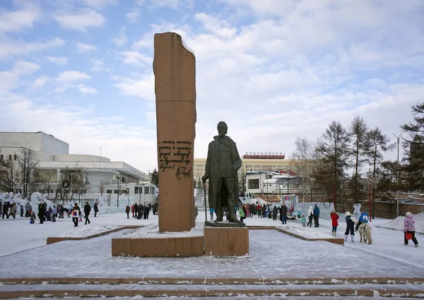Krasnojarsk, Rf - 11 januari 2014: Monument aan de schrijver A. Tsjechov aan de kade van de winter stad met de rust mensen. — Stockfoto