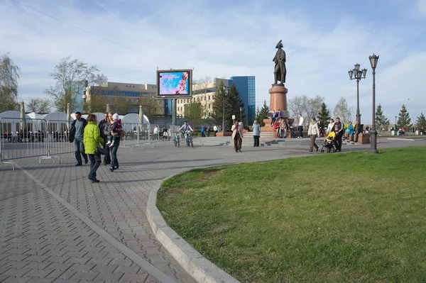 KRASNOYARSK, RF - 1 de mayo de 2013: Plaza del Mundo con un monumento a Nikolai Rezanov y gente caminando . — Foto de Stock