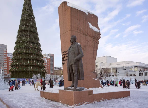 Monument of writer Anton Chekhov on the background of the city's main Christmas tree. — Stock Photo, Image