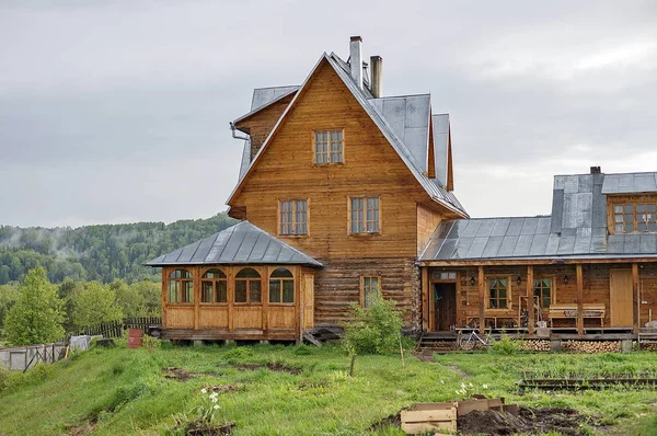 Uma grande casa rural de madeira com uma folha de metal, um telhado . — Fotografia de Stock