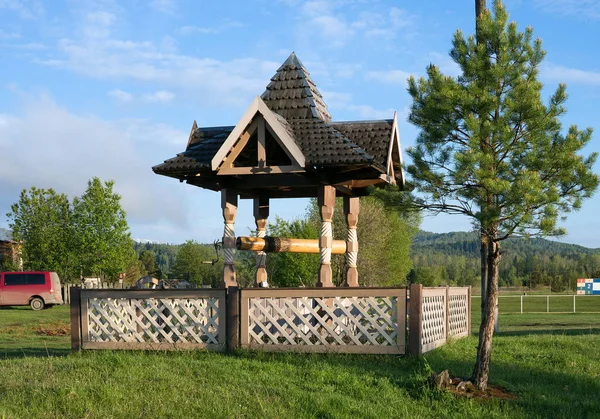 A stylish wooden well with a roof in the village. — Stock Photo, Image