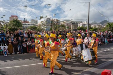 Seyirci ve şehrin fon karşı sarı elbiseli bir müzik Orkestrası.