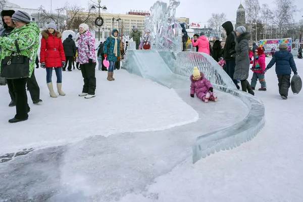 Kinderen rijden op een heuvel van ijs in de stad in een ijzige. — Stockfoto