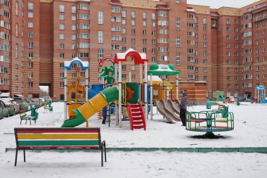 NOVOSIBIRSK, RF - November 8, 2017: Rest zone in the courtyard of a residential building with a playground. Novosibirsk Region, Russia. clipart