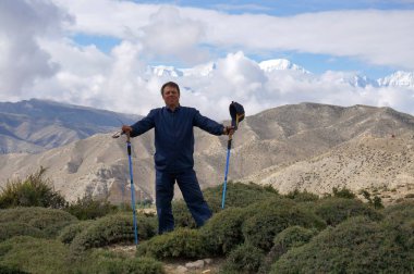 Turist gülümseyen Annapurna masifinin zemin karşı trekking sopa ile duruyor. Üst Mustang trekking. Nepal.