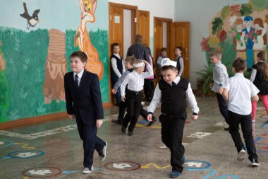 BELOGORSK, KEMEROVO REGION, RF- March 22,2018: School children run  in the school hall during a noon recess  between lessons. The children have playtime after lunch. clipart
