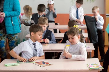 Belogorsk, Kemerovo bölgesi, Rf-Mart 22,2018: Öğrenciler masa başında oturmak ve sonra derste kırsal İlköğretim Okulu okul sınıf kalemler bak.