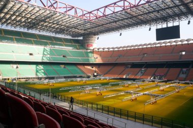 Milano, San Siro / İtalya - 22 Ocak 2019: İnsanlar, Giuseppe Meazza Stadyumu 'ndaki (1925) doğal çimlerin taşınabilir ışıklandırılmasıyla futbol arenası boyunca yürür.).