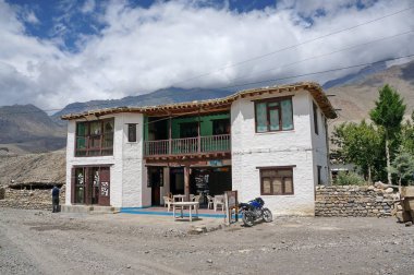 Kagbeni, Mustang / Nepal - 21 Ağustos 2014: Yukarı Mustang 'e giden Himalaya dağlarının arka planında turistler için iki katlı beyaz otel.