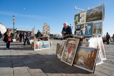 Venedik / İtalya - 24 Ocak 2019: Sanatçılar resimlerini Venedik, İtalya 'da güneşli bir günde Riva degli Schiavoni' nin (Slavyanskaya) merkez güvertesinde turistlere sattılar.