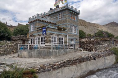 Jomsom, Mustang / Nepal - 21 Ağustos 2014: İki katlı Yeti Oteli Himalaya Dağları 'nın arka planına karşı nehir kıyısında yer almaktadır..