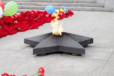 İkinci Dünya Savaşı 'nda ölenlerin anısına, yıldız şeklinde sonsuz bir alev taze çiçeklerin arasında yanar..