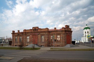 Yeniseisk, Krasnoyarsk Bölgesi / RF - 13 Ekim 2019: Bulutlu bir sonbahar gününde Epiphany Katedrali 'nin zeminine karşı Zamaraev ticaret malikanesinin (19. yüzyılın sonlarında) inşası. 