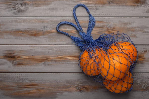 Apelsiner i en nätväska av naturmaterial. Miljöskydd — Stockfoto