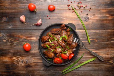 Soya soslu, domatesli, soğanlı ve ahşap kaplamalı ev yapımı tavuk ciğeri. Üst görünüm